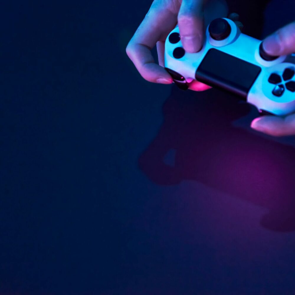 High angle view of male hands holding game controller. Professional computer game playing, esport business and online world concept.